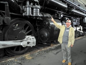 Charles Hardy is dwarfed by  his beloved steam locomotive. Photo by Clark Norton