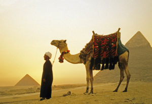 Man with camel at Great Pyramid of Giza at sunset. Photo by Dennis Cox/WorldViews