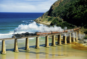 South Africa: Outeniqua Choo Tjoe steam train crossing tressel at mouth of Kaimans River on Indian Ocean. Photo by Dennis Cox/WorldViews