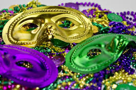 Mardi Gras masks and beads in traditional colors of green, gold and purple.